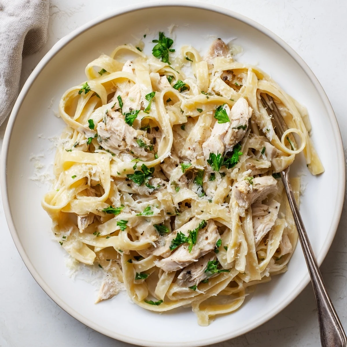 Creamy Crock Pot Chicken Alfredo with tender shredded chicken and al dente fettuccine pasta in a rich parmesan sauce