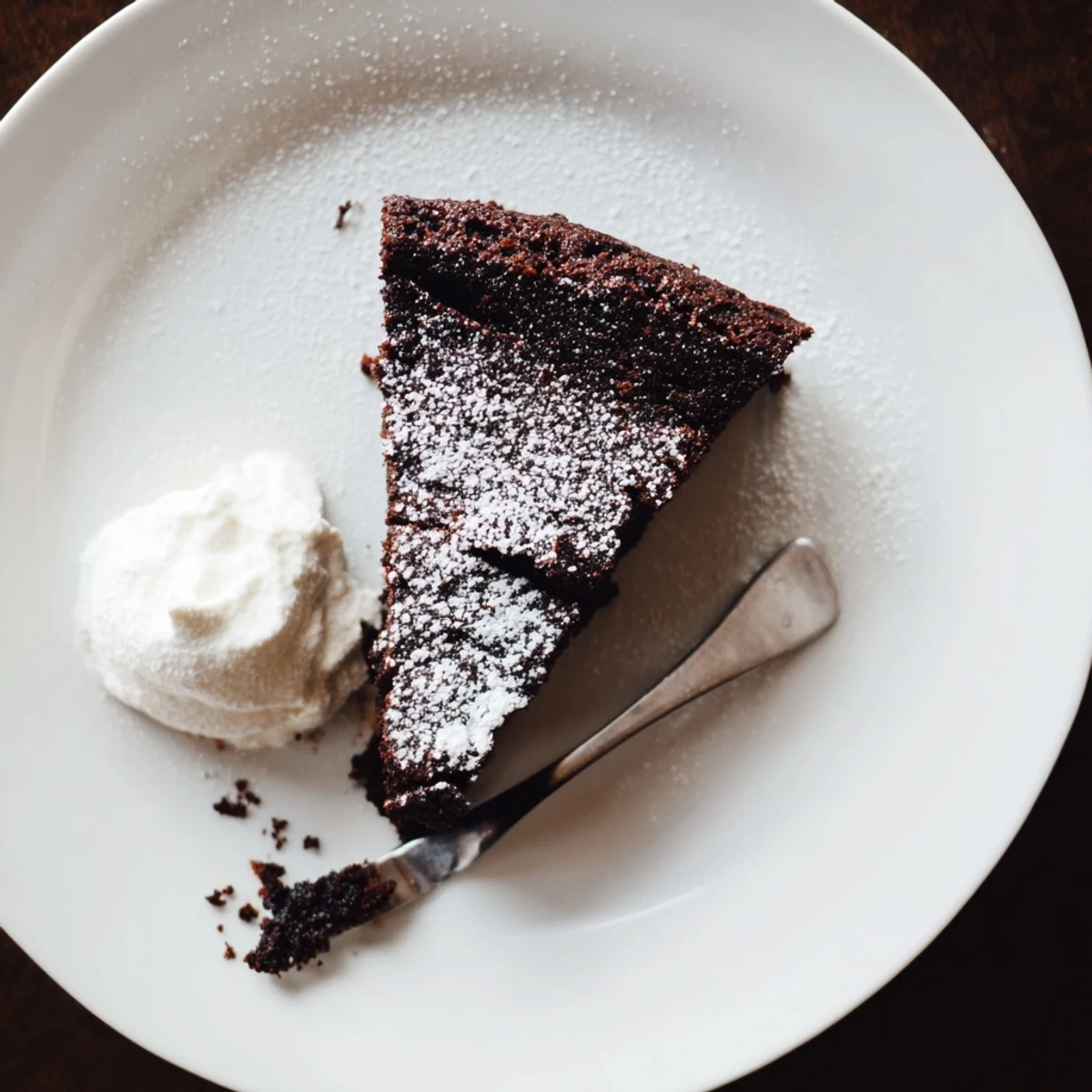 Moist air fryer Guinness chocolate cake dusted with powdered sugar on a white plate