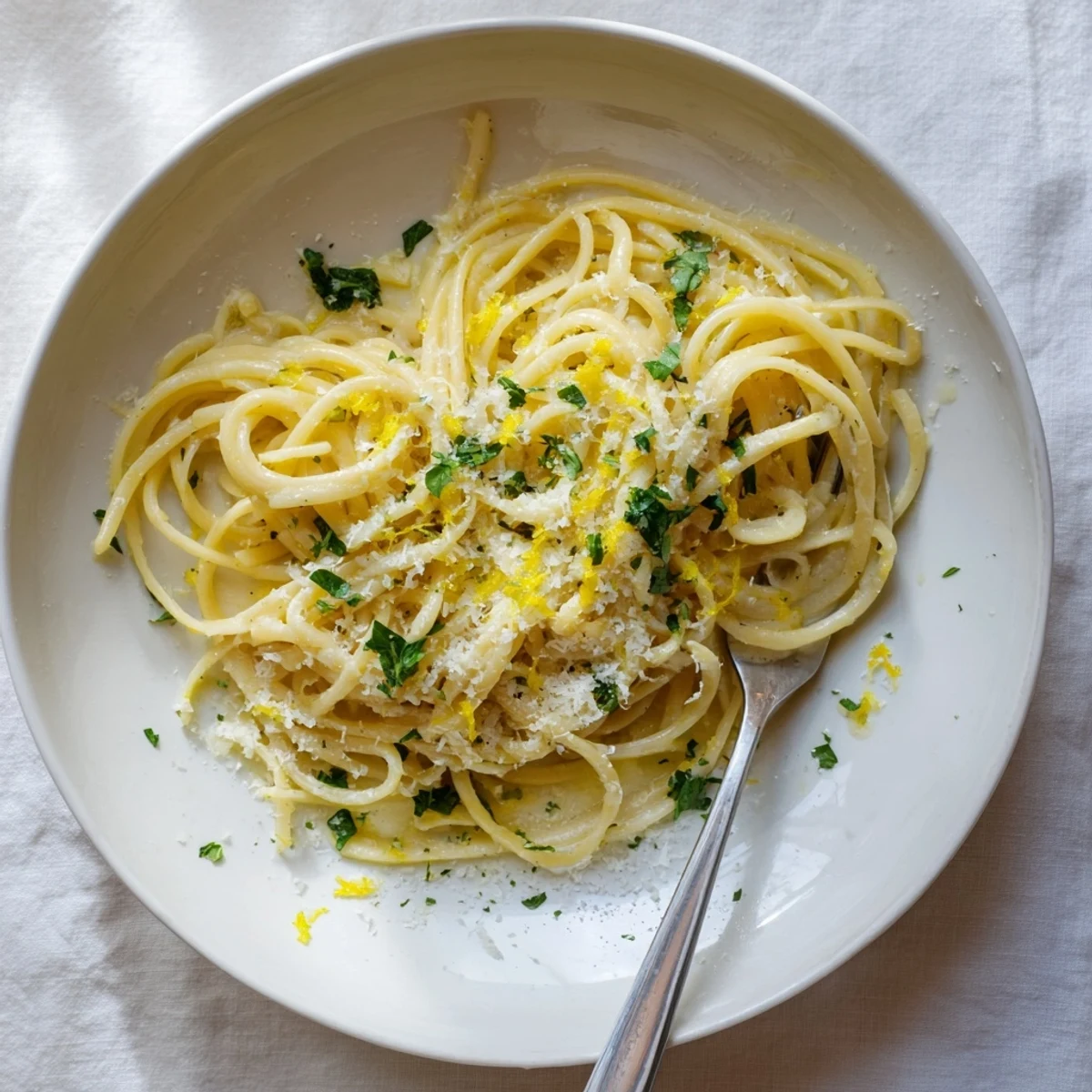 Steaming bowl of garlic butter pasta tossed in silky sauce and topped with grated cheese