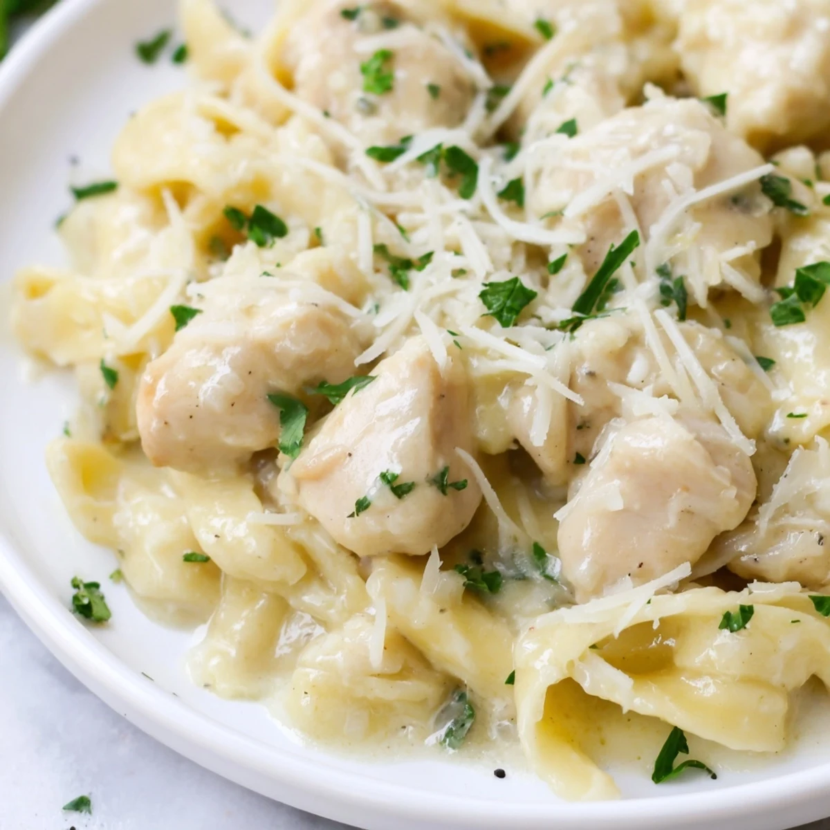Comforting Italian-American fettuccine dish with juicy chicken and velvety parmesan cream sauce served family style