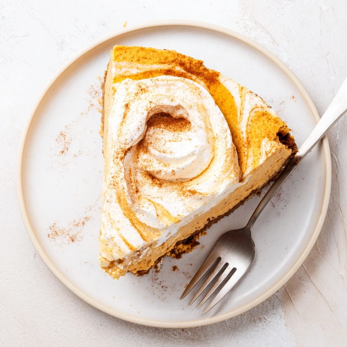 Holiday pumpkin spice Christmas cheesecake slice revealing graham cracker crust and whipped topping