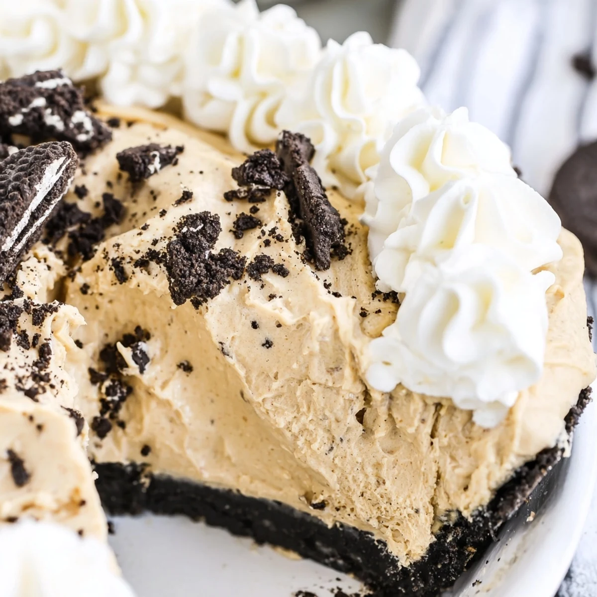 Rich peanut butter Oreo pie sliced to reveal layers of chocolate crust and creamy filling
