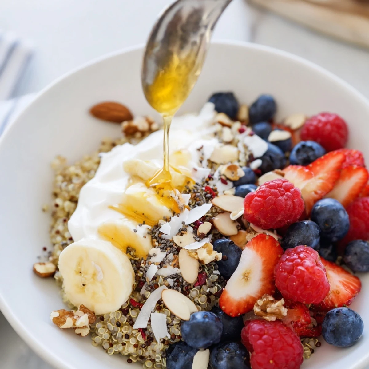 Quinoa Breakfast Bowl topped with creamy yogurt, bright berries, and crunchy nuts