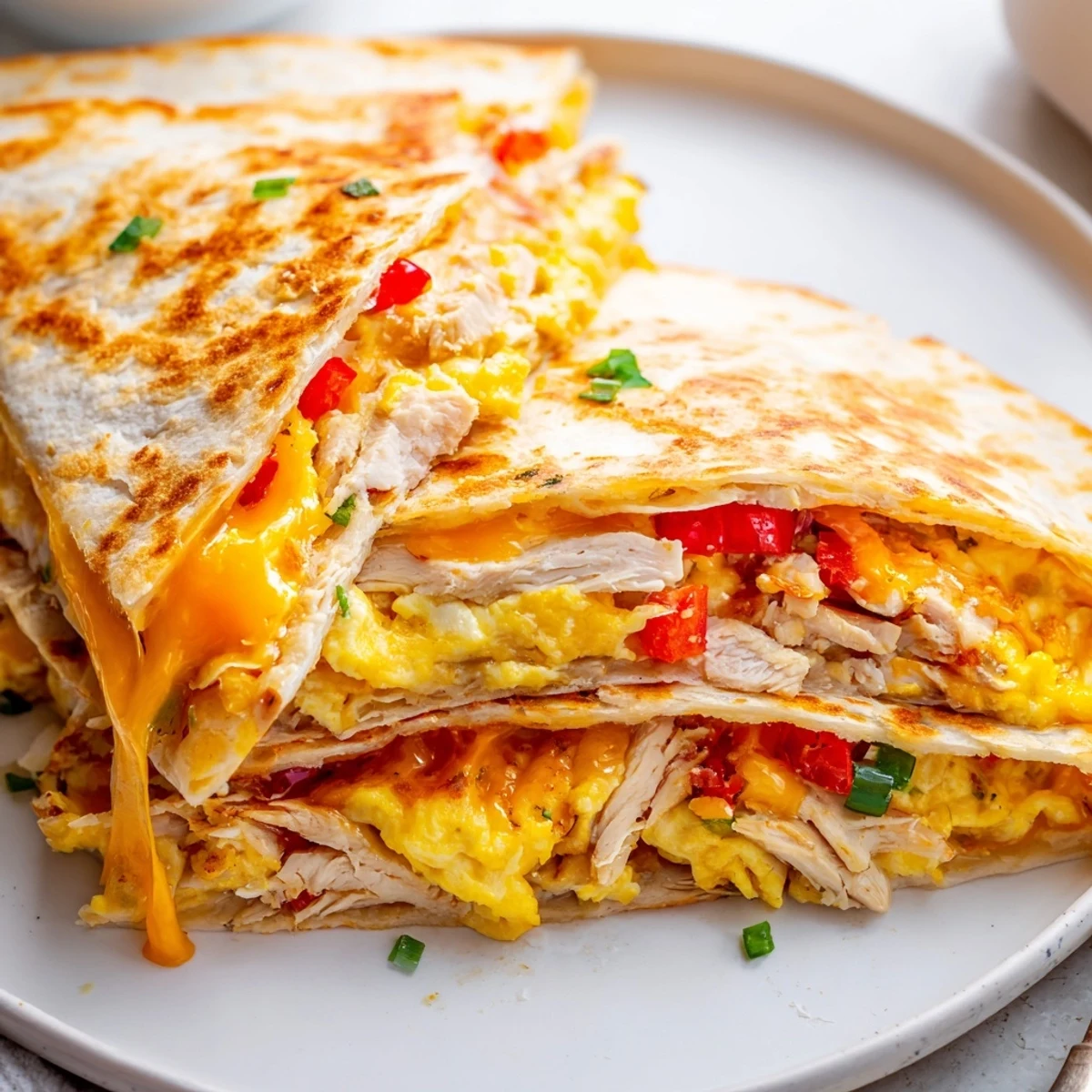 Pan-toasted Chicken Breakfast Quesadilla oozing cheddar, scrambled eggs, and peppers.