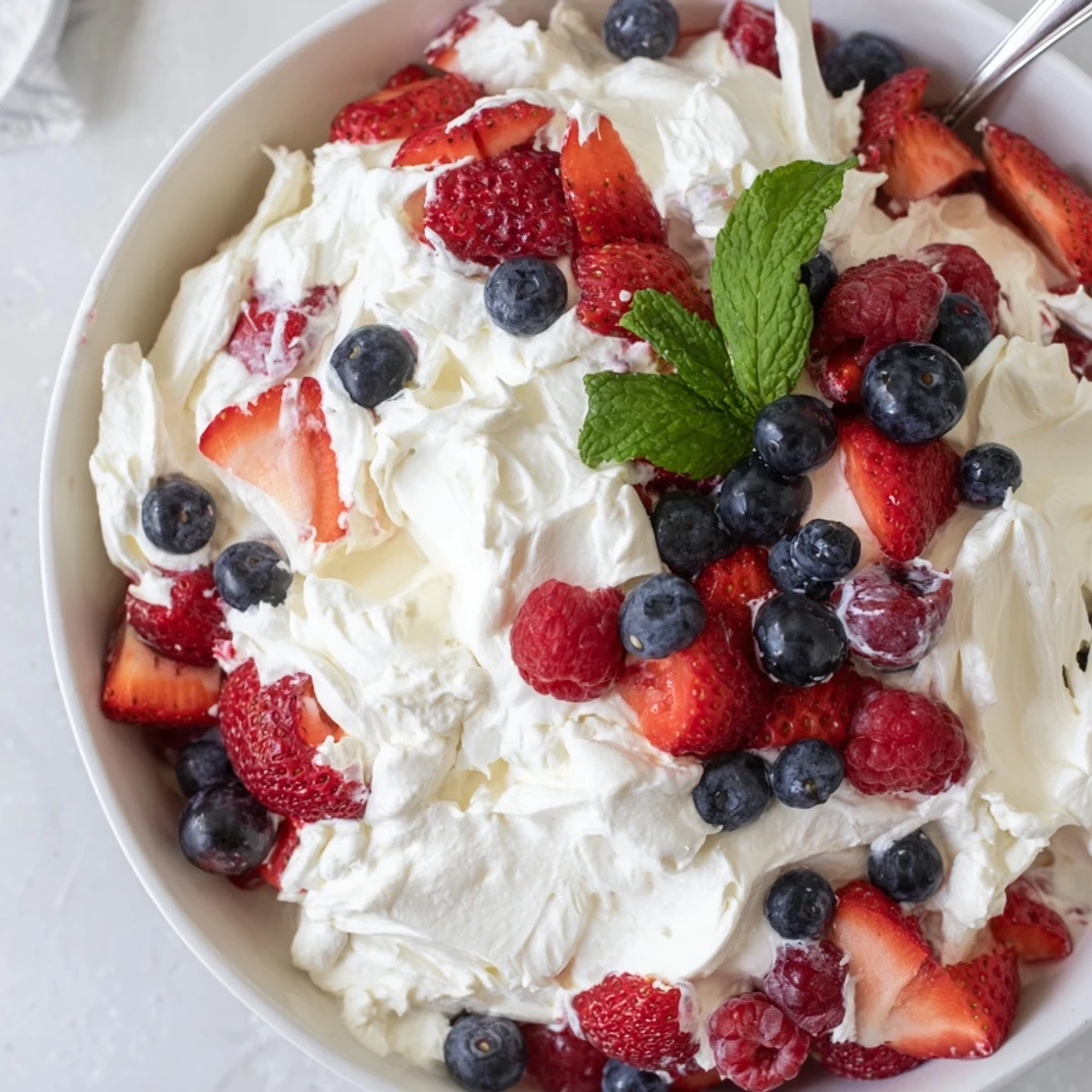 Chilled Red White Blue Cheesecake Salad spooned into glasses for summer gatherings