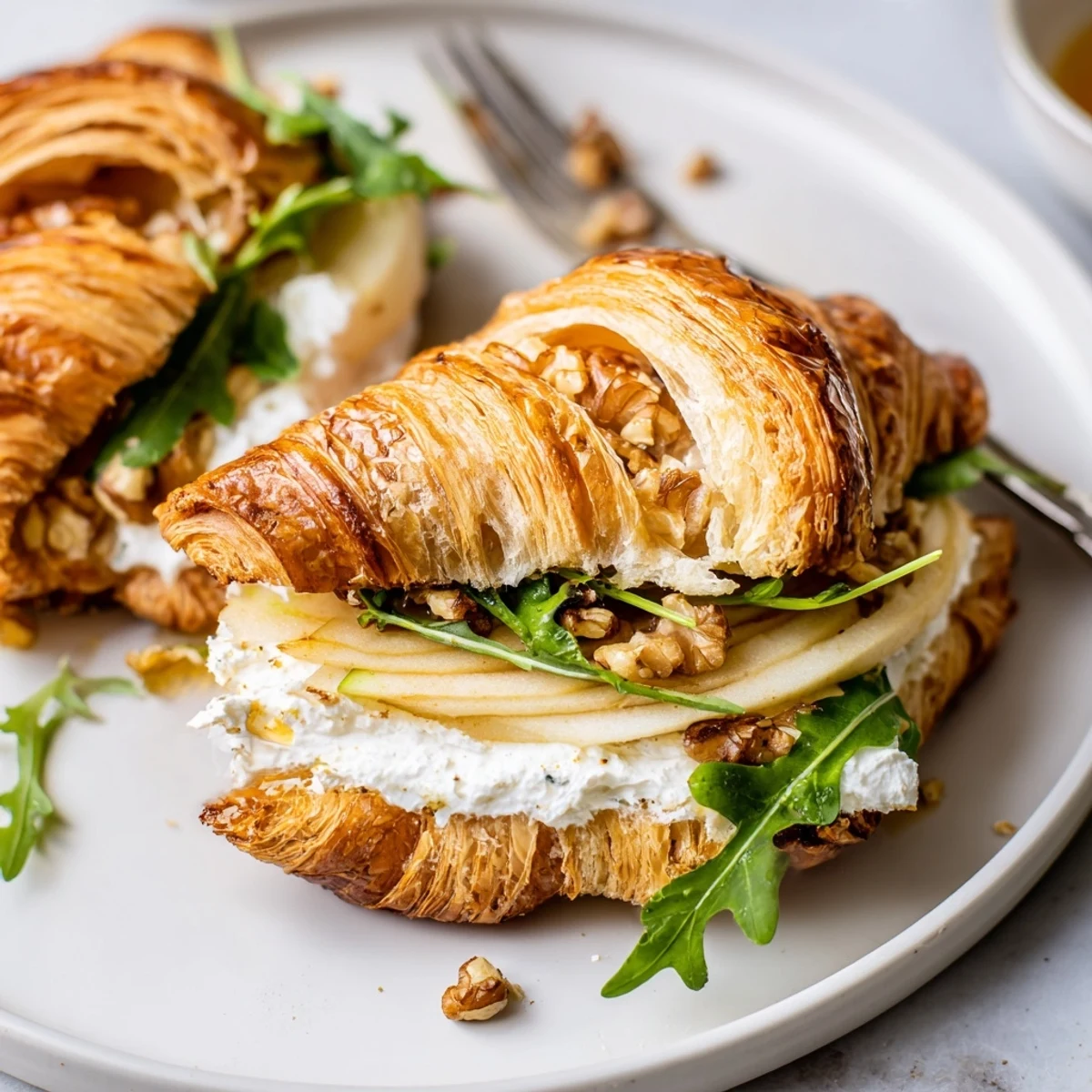 Golden croissant sandwich with creamy tang, crunchy walnuts, enjoy Apple Goat Cheese Croissant Sandwich