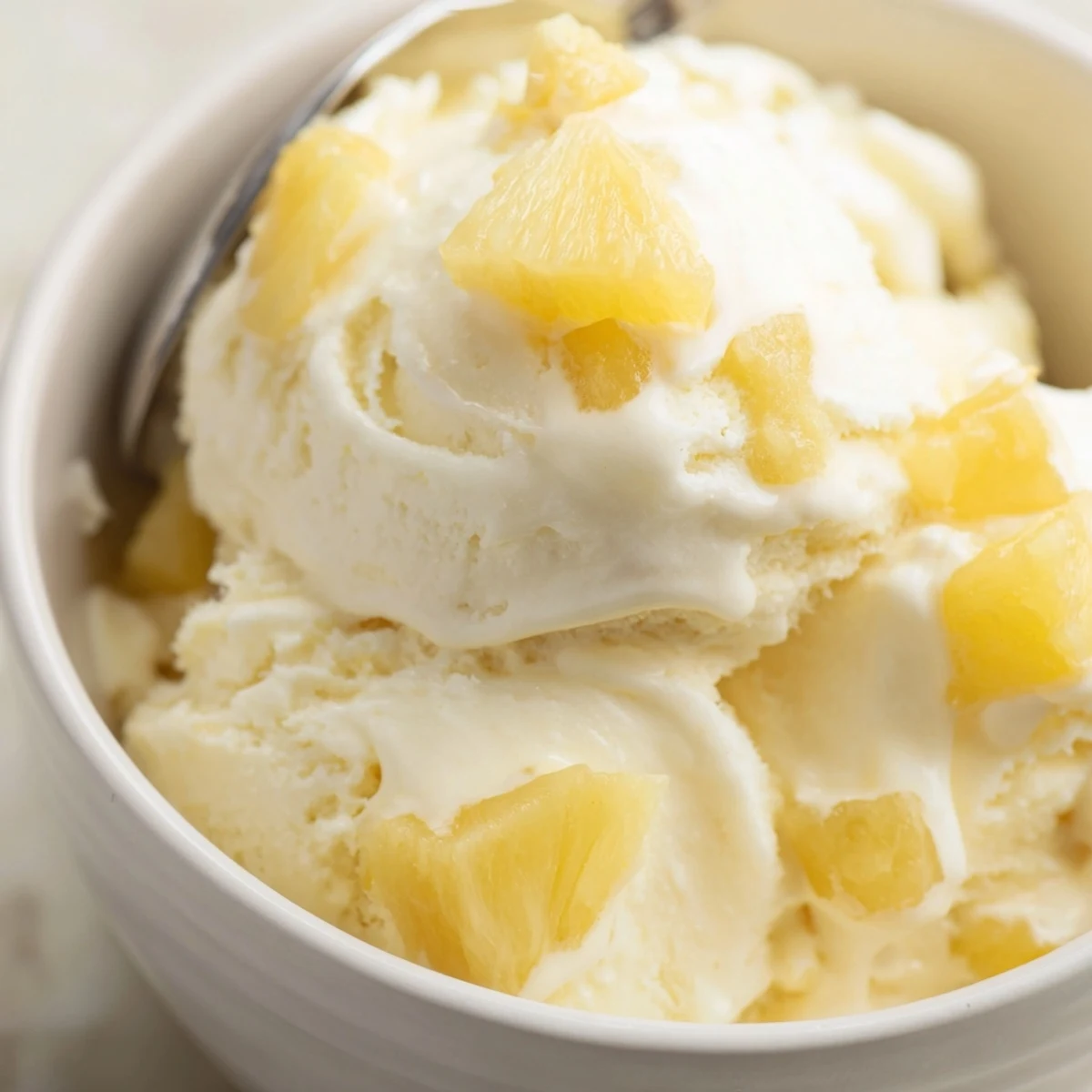 Creamy Pineapple Ice Cream Recipe: silky golden scoops topped with toasted coconut