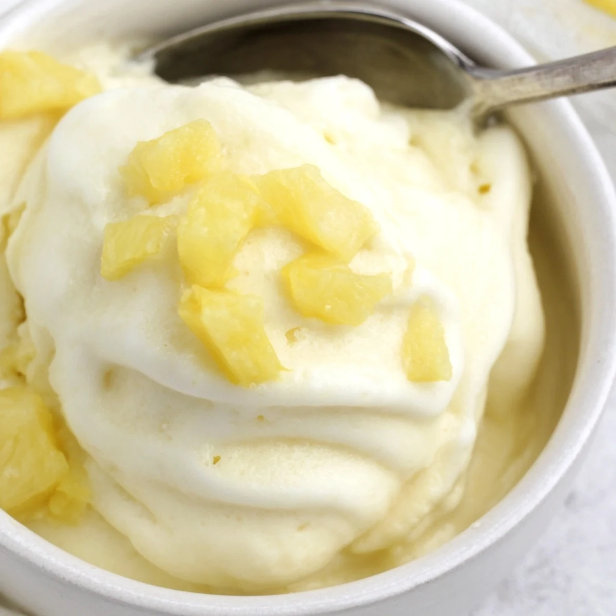 A chilled bowl of Creamy Pineapple Ice Cream with bright citrus aroma