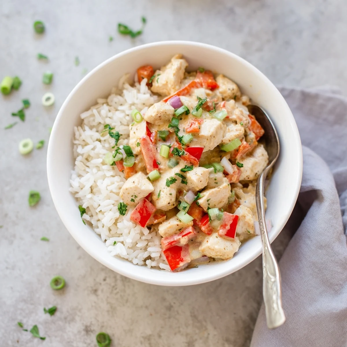 Colorful bell peppers simmered in spicy creamy sauce top tender seasoned chicken bowls