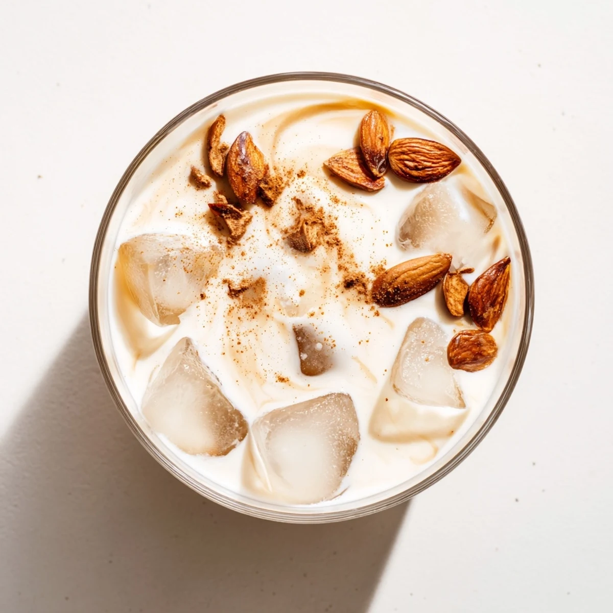 Light nutty refreshing summer roasted almond milk drink with cream in a chilled glass