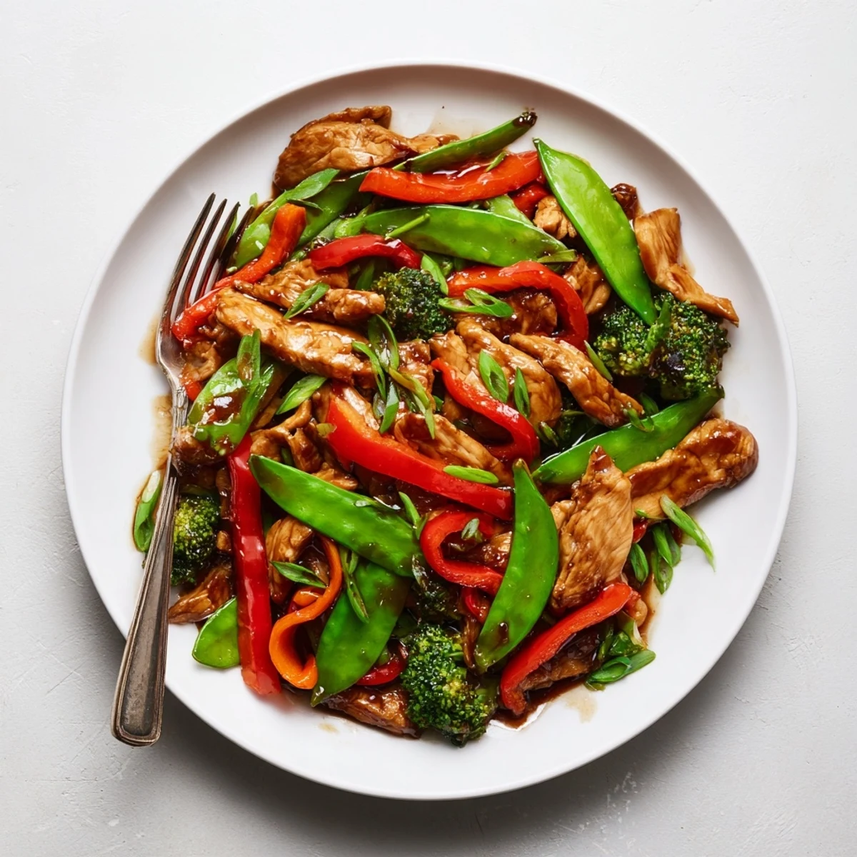 Sizzling Hunan Chicken with colorful bell peppers and broccoli in a spicy garlic sauce