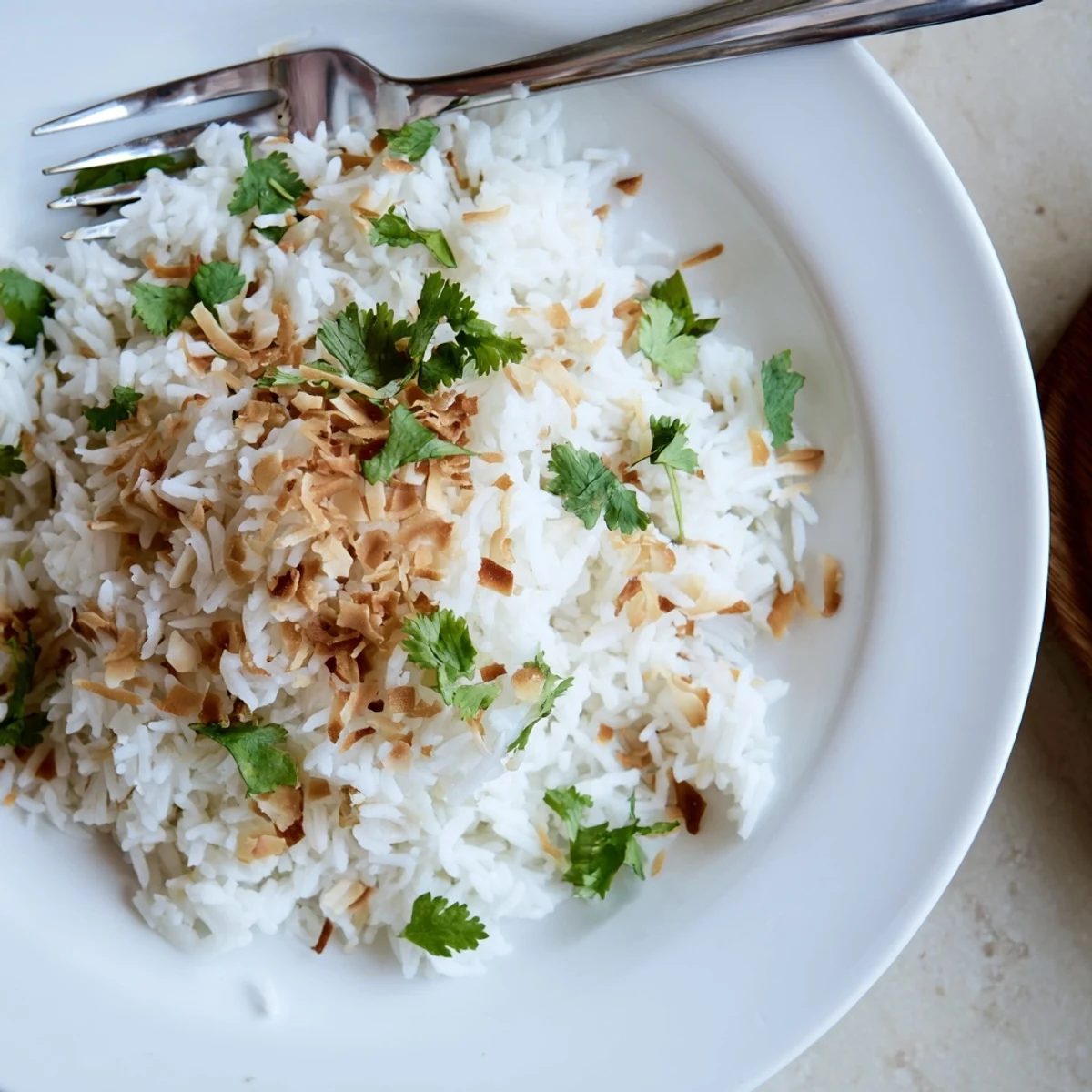 Steaming bowl of coconut rice served alongside a rich Thai curry